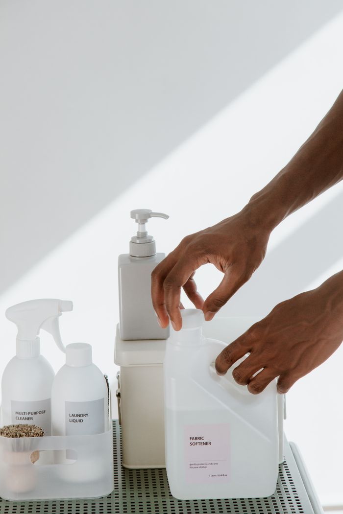 Crafting Captivating Headlines: Your awesome post title goes here Close-up of hands organizing various cleaning products on a white surface, showcasing cleanliness and home care essentials.